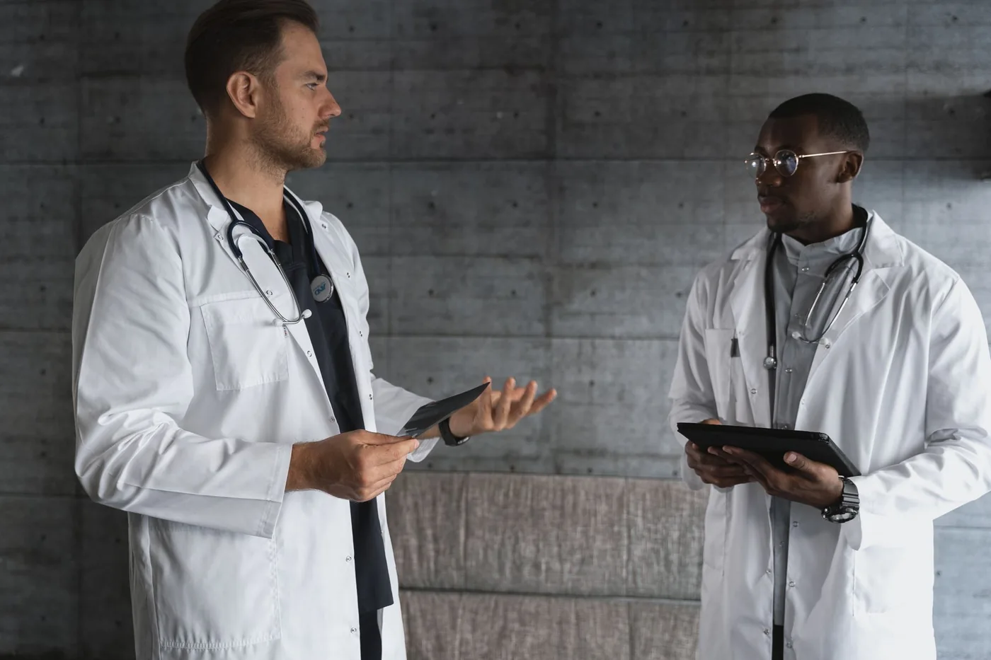 Two clinicians discussing information on tablets