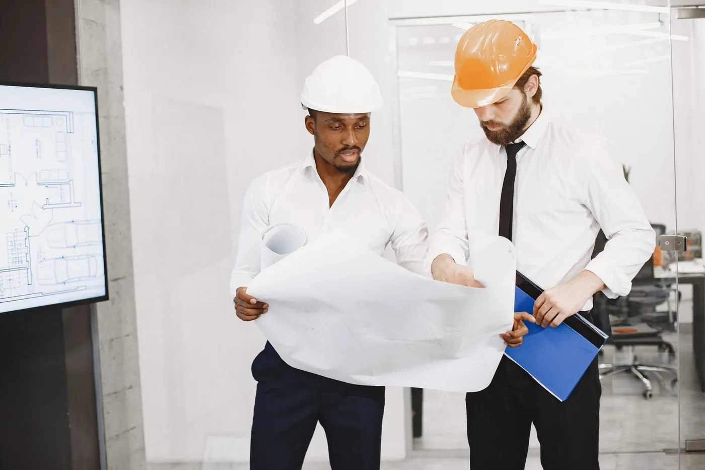 Two professionals reviewing blueprints